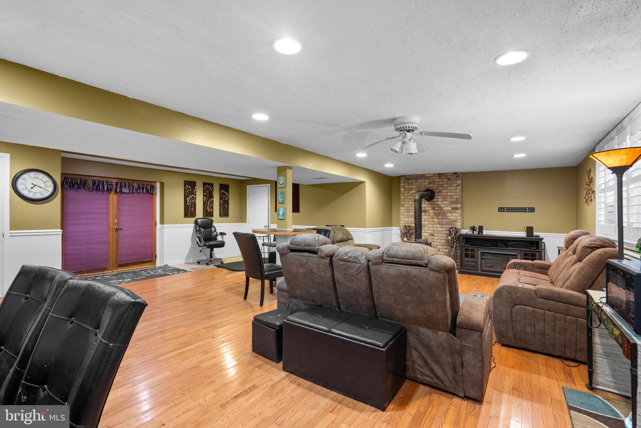 13100 Croom Road Upper Marlboro, MD 20772 - Photo 25 of 37 a living room with furniture a red lamp and a projector