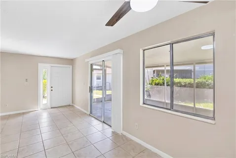 a view of an empty room with glass door and windows