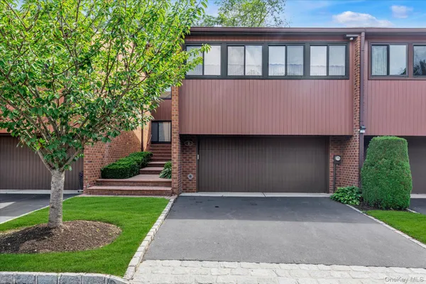 a front view of a house with a yard and a garage