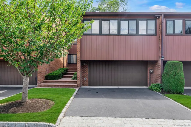 a front view of a house with a yard and a garage