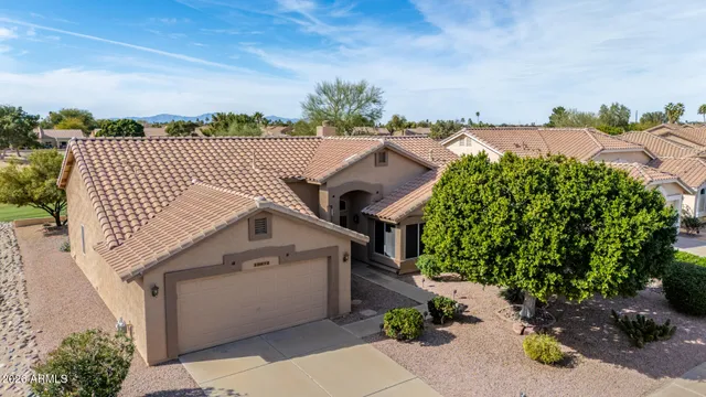 an aerial view of a house with a yard and mountain view in back
