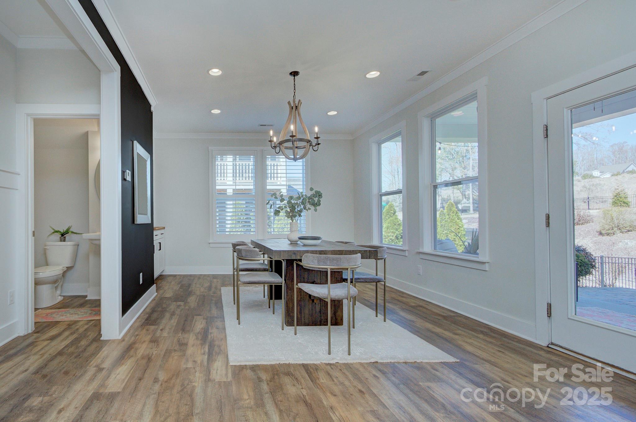1176 Weir Court Fort Mill, SC 29708 - Photo 16 of 35 a dining room with wooden floor and a chandelier