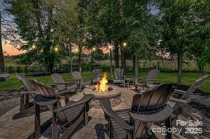 1176 Weir Court Fort Mill, SC 29708 - Photo 28 of 35 a view of a patio with table and chairs potted plants and large tree