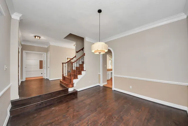 an empty room with wooden floor fireplace and windows