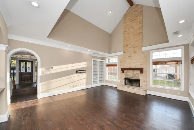 a view of a yard in front of a house with plants and large tree