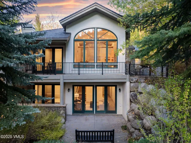 a view of a brick house with a large windows and a lawn chairs