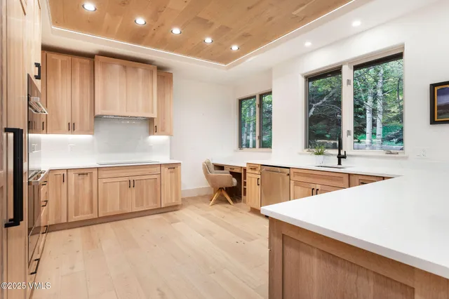 a kitchen with stainless steel appliances kitchen island granite countertop a sink and a stove top oven