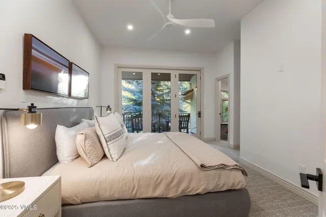 a bedroom with a large bed and a flat tv screen on dresser