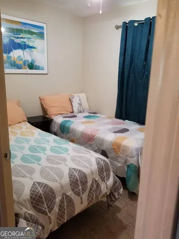 a bedroom with two beds and a painting on the wall