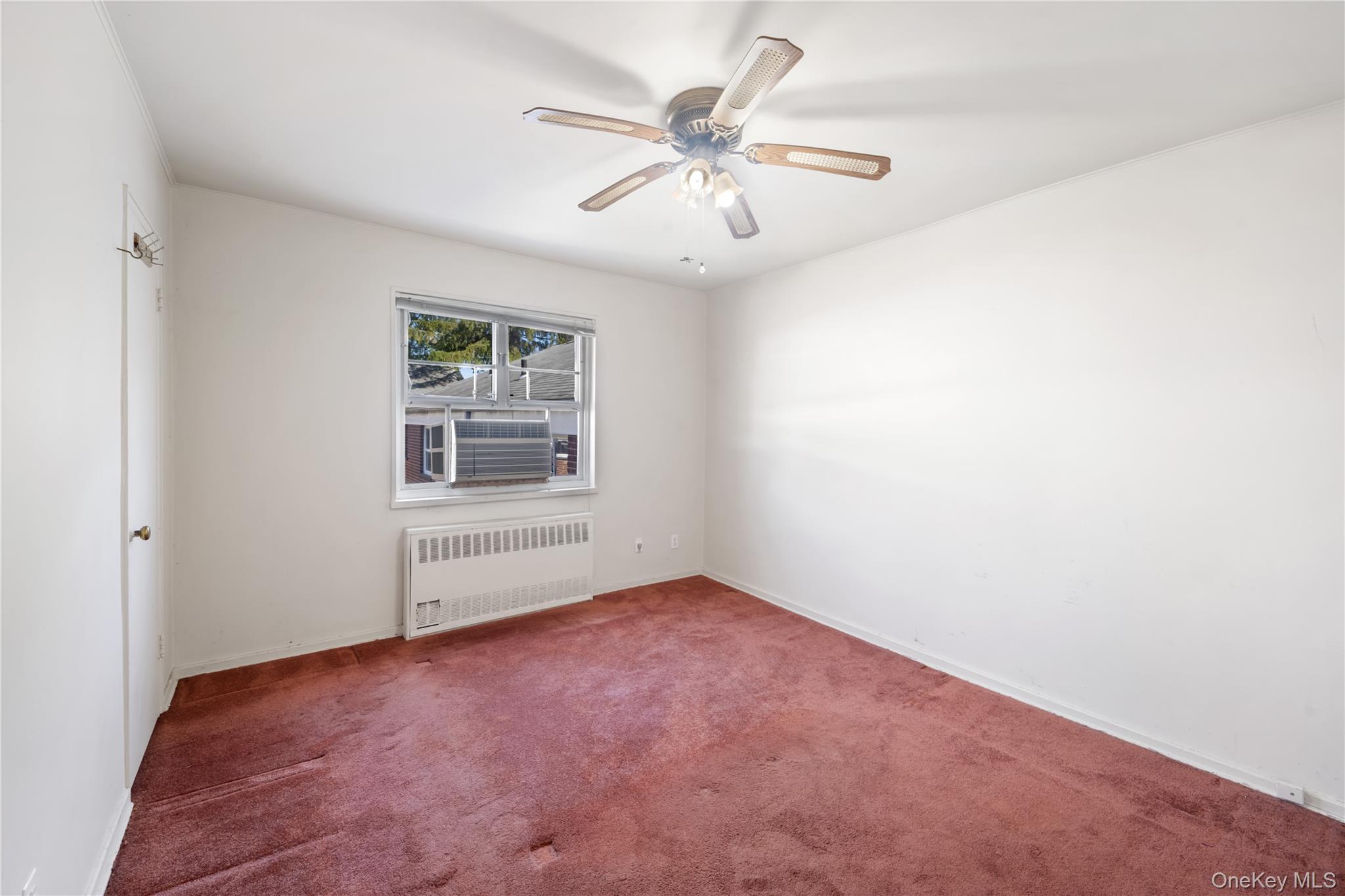 226-29 Manor Road, Unit UPPR Queens, NY 11427 - Photo 12 of 21 Carpeted spare room featuring radiator and ceiling fan