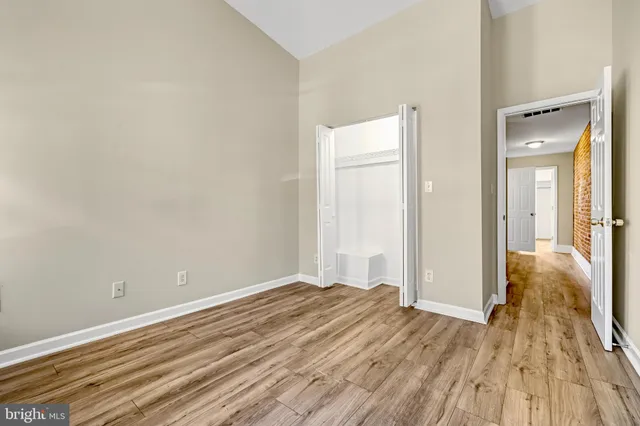 a view of a room with wooden floor and a bathroom