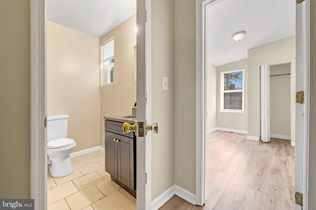 a bathroom with a granite countertop toilet and a sink