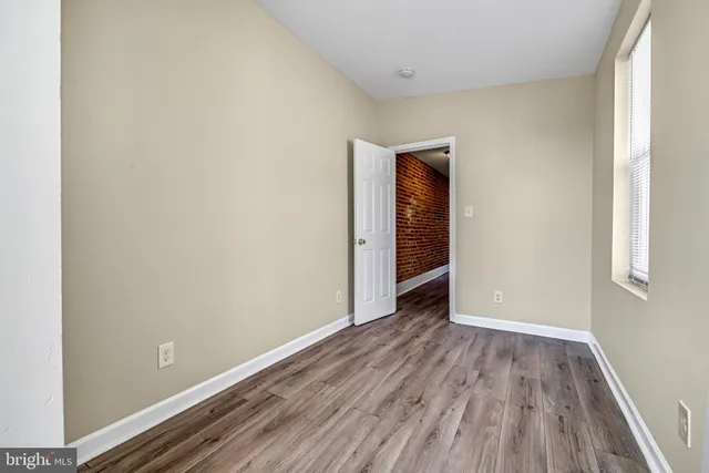 a view of an empty room with closet and a window
