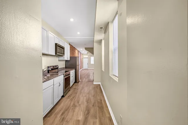 a kitchen with stainless steel appliances a refrigerator a stove top oven a sink and dishwasher