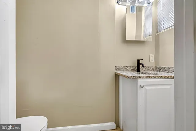 a bathroom with a sink a toilet and a mirror