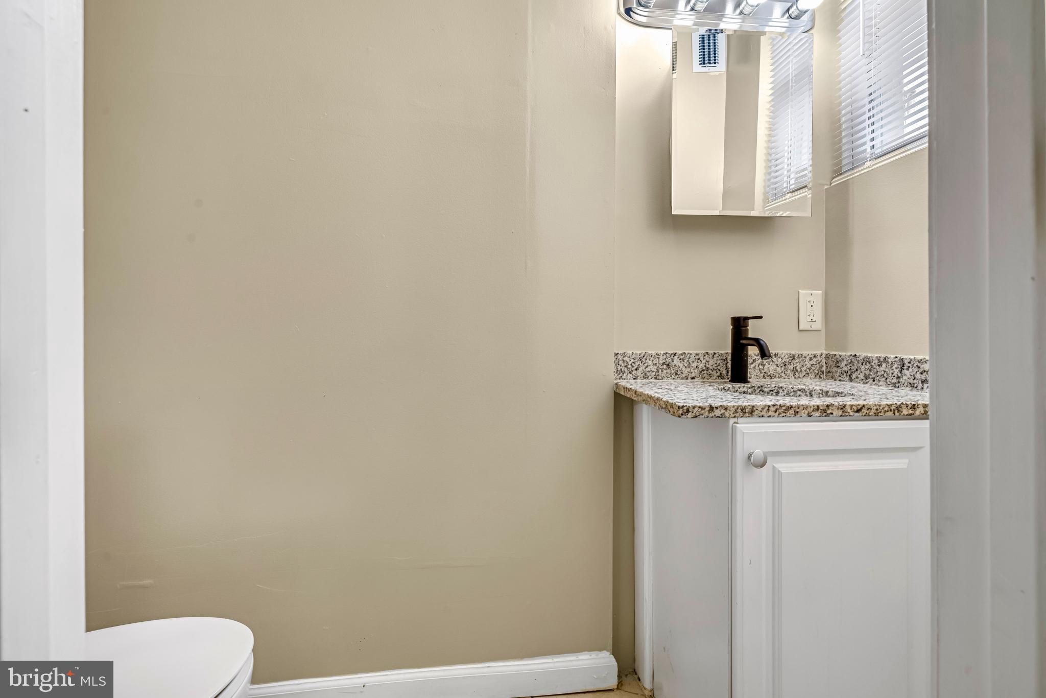 2131 Jefferson Street Baltimore, MD 21205 - Photo 7 of 24 a bathroom with a sink a toilet and a mirror