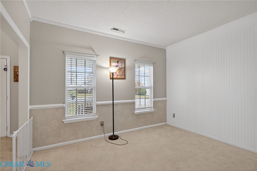 116 Old Field Road Williamsburg, VA 23188 - Photo 9 of 27 Spare room with a textured ceiling, crown molding, and light carpet