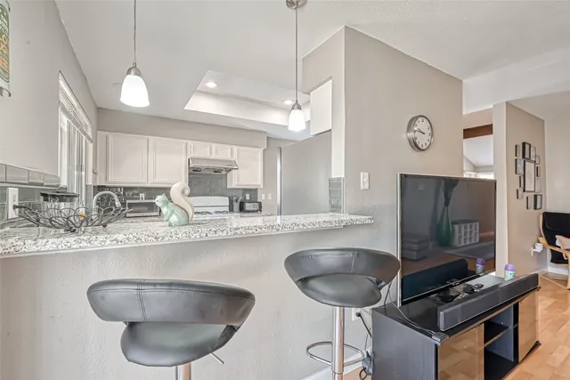 a kitchen with stainless steel appliances granite countertop a sink a microwave a refrigerator and chairs