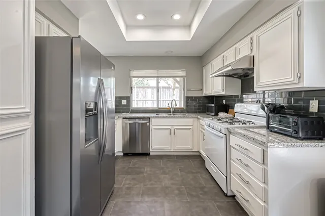 a kitchen with white cabinets and white appliances