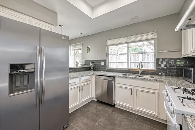 a kitchen with a refrigerator sink and cabinets