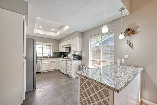 a kitchen with kitchen island granite countertop a sink cabinets and window