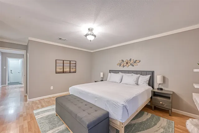 a spacious bedroom with a bed and a chandelier