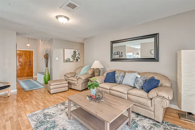 a living room with furniture and wooden floor