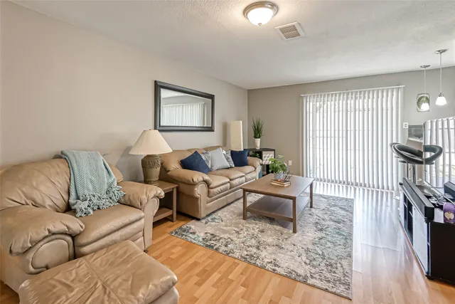 a living room with furniture and a wooden floor