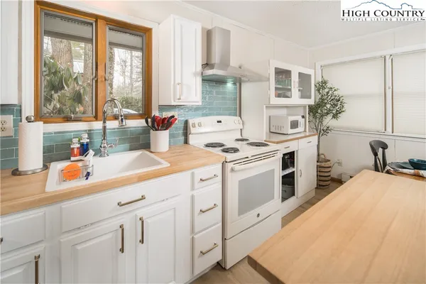 a kitchen with white cabinets and white appliances