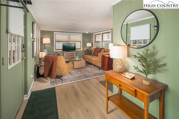 a living room with furniture a mirror and a flat screen tv