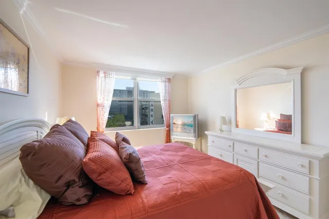 a bed room with a bed and a painting on the wall