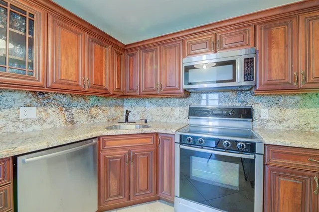 a kitchen view with cabinets a sink and appliances