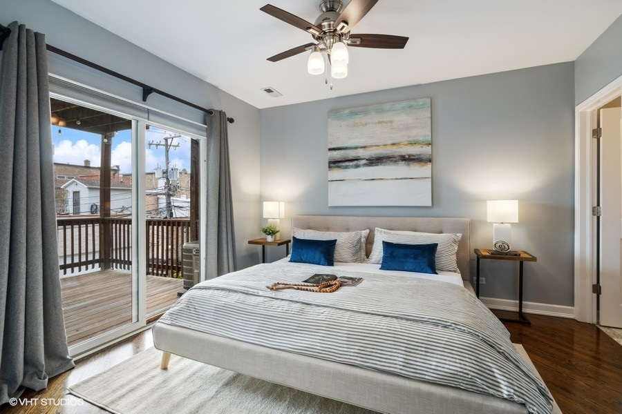 1219 West Melrose Street, Unit 2 Chicago, IL 60657 - Photo 9 of 13 a bedroom with a large bed and a chandelier
