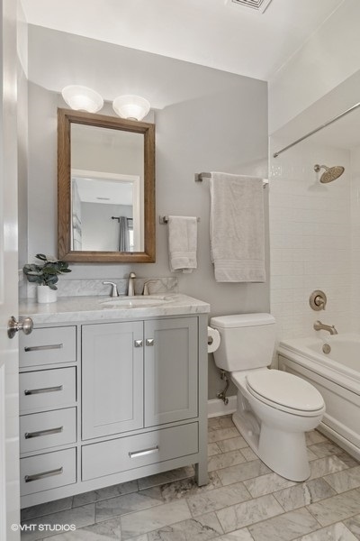 1219 West Melrose Street, Unit 2 Chicago, IL 60657 - Photo 10 of 13 a bathroom with a granite countertop toilet sink and a mirror