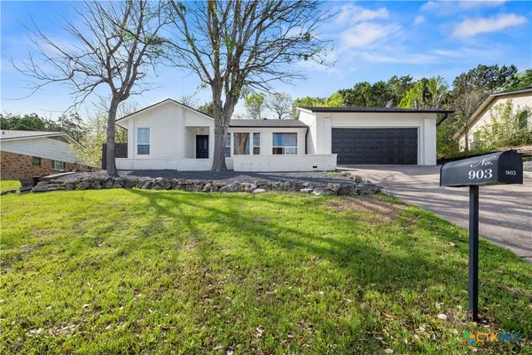 a front view of house with yard and trees