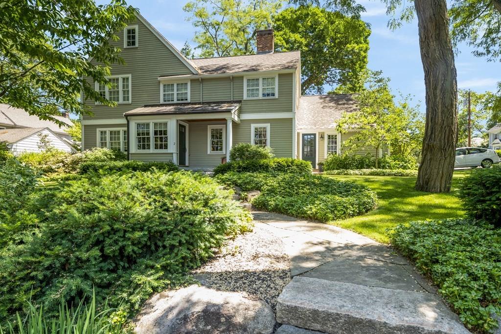 a front view of a house with a yard and potted plants