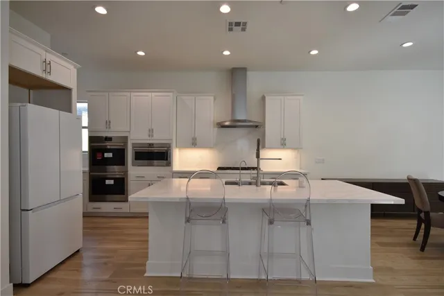 a kitchen with kitchen island sink stove and refrigerator