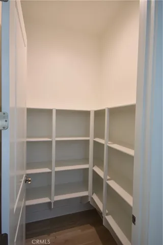 a kitchen with a dining table chairs and wooden floor