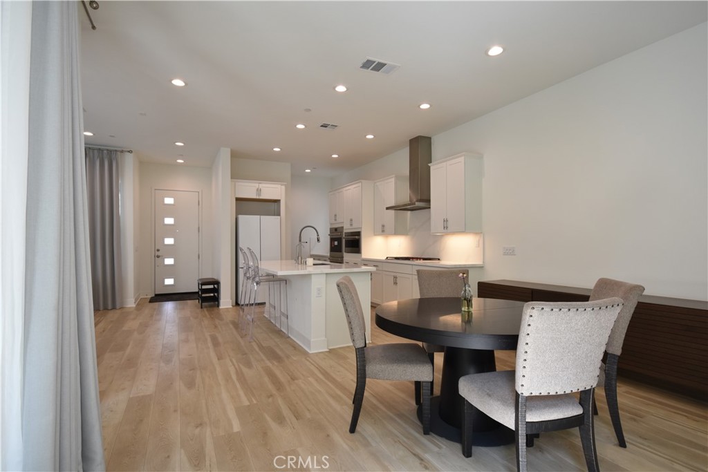 364 Baluster Irvine, CA 92618 - Photo 16 of 56 a kitchen with a dining table chairs and wooden floor