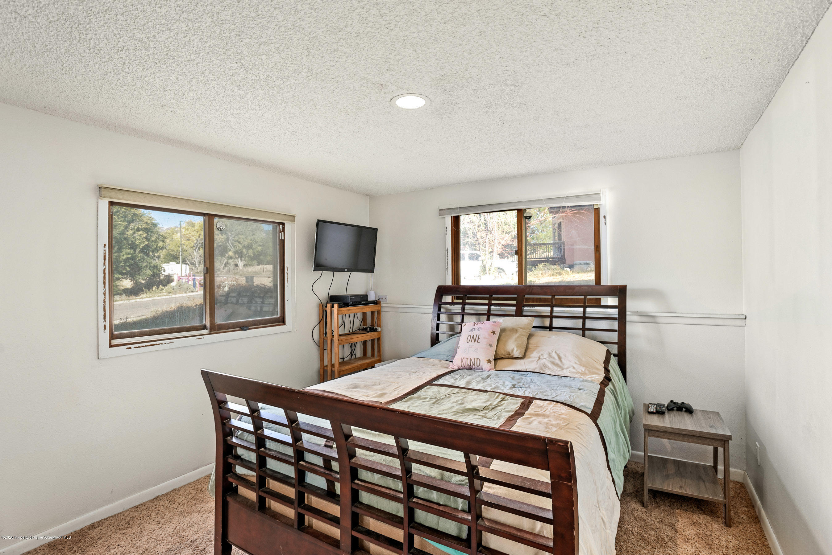 690 Moki Avenue Rifle, CO 81650 - Photo 5 of 15 a bedroom with a bed a table and a large mirror next to a window