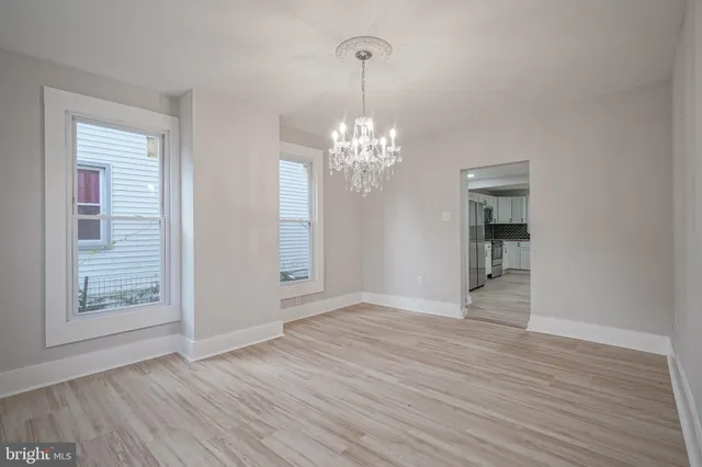 a view of a livingroom with wooden floor and a chandelier