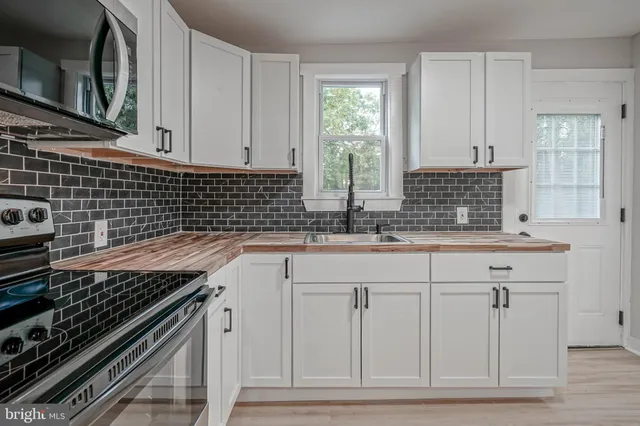 a kitchen with granite countertop a sink stove and cabinets