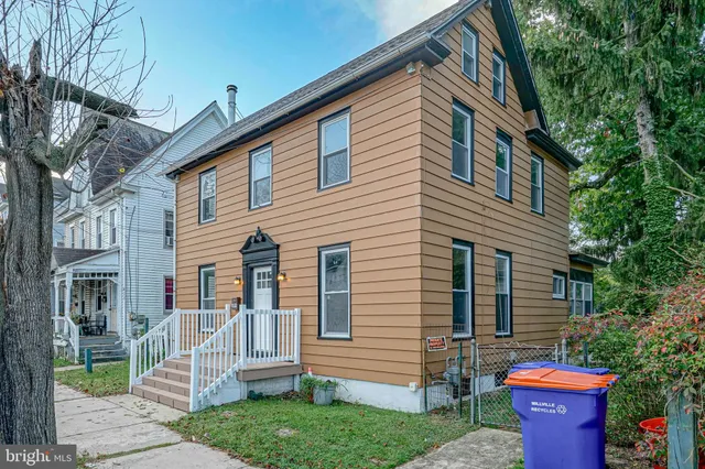 a front view of a house with a garden and plants