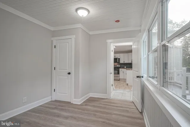 a view of a large kitchen with wooden floor and a window