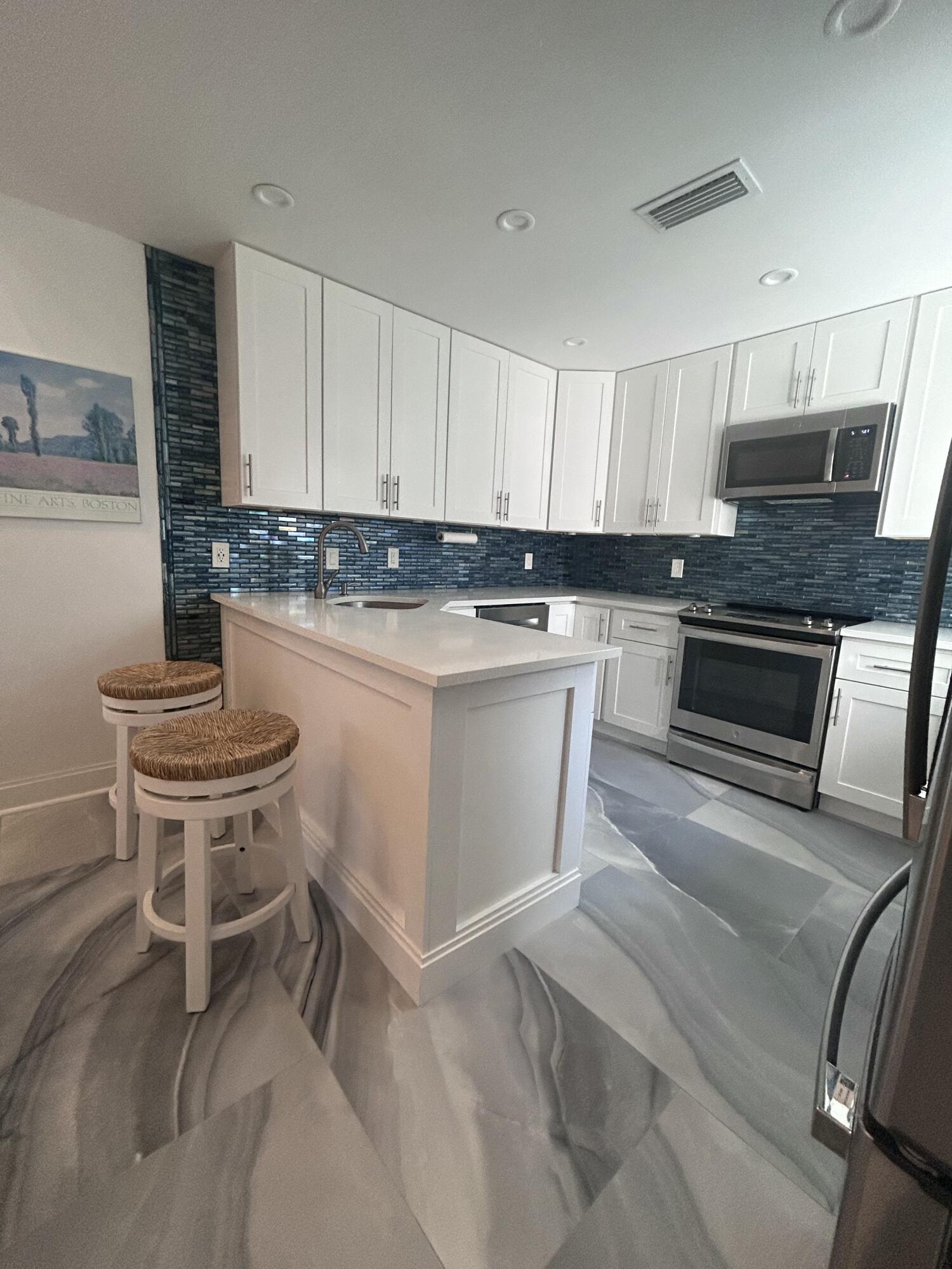 a kitchen with a stove a sink and white cabinets