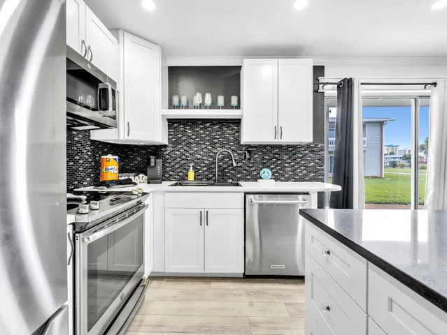 a kitchen with stainless steel appliances granite countertop a stove a sink and a microwave