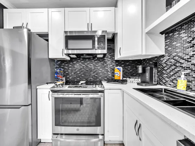 a kitchen with stainless steel appliances a stove a microwave and a refrigerator