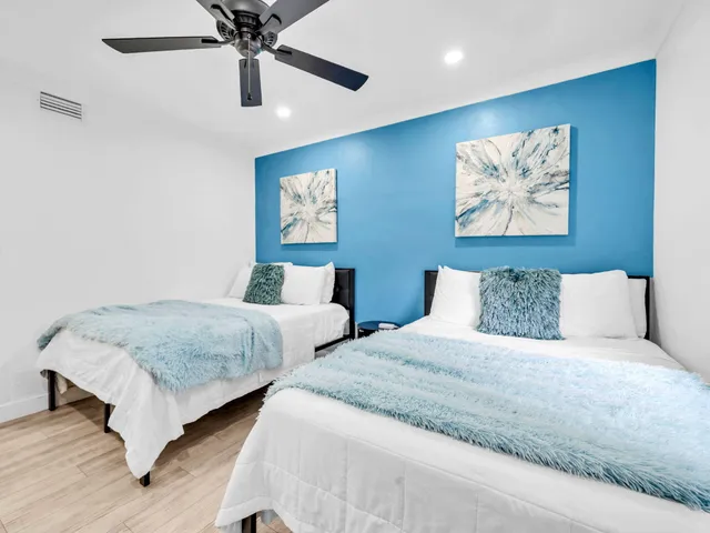 a bedroom with two beds and painting on the wall