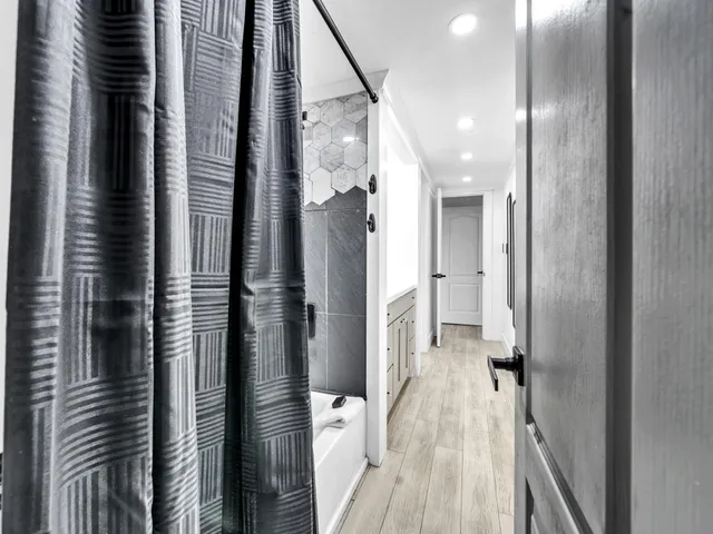 a view of a hallway with wooden floor and staircase