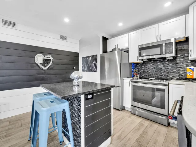 a kitchen with stainless steel appliances granite countertop a stove and a refrigerator